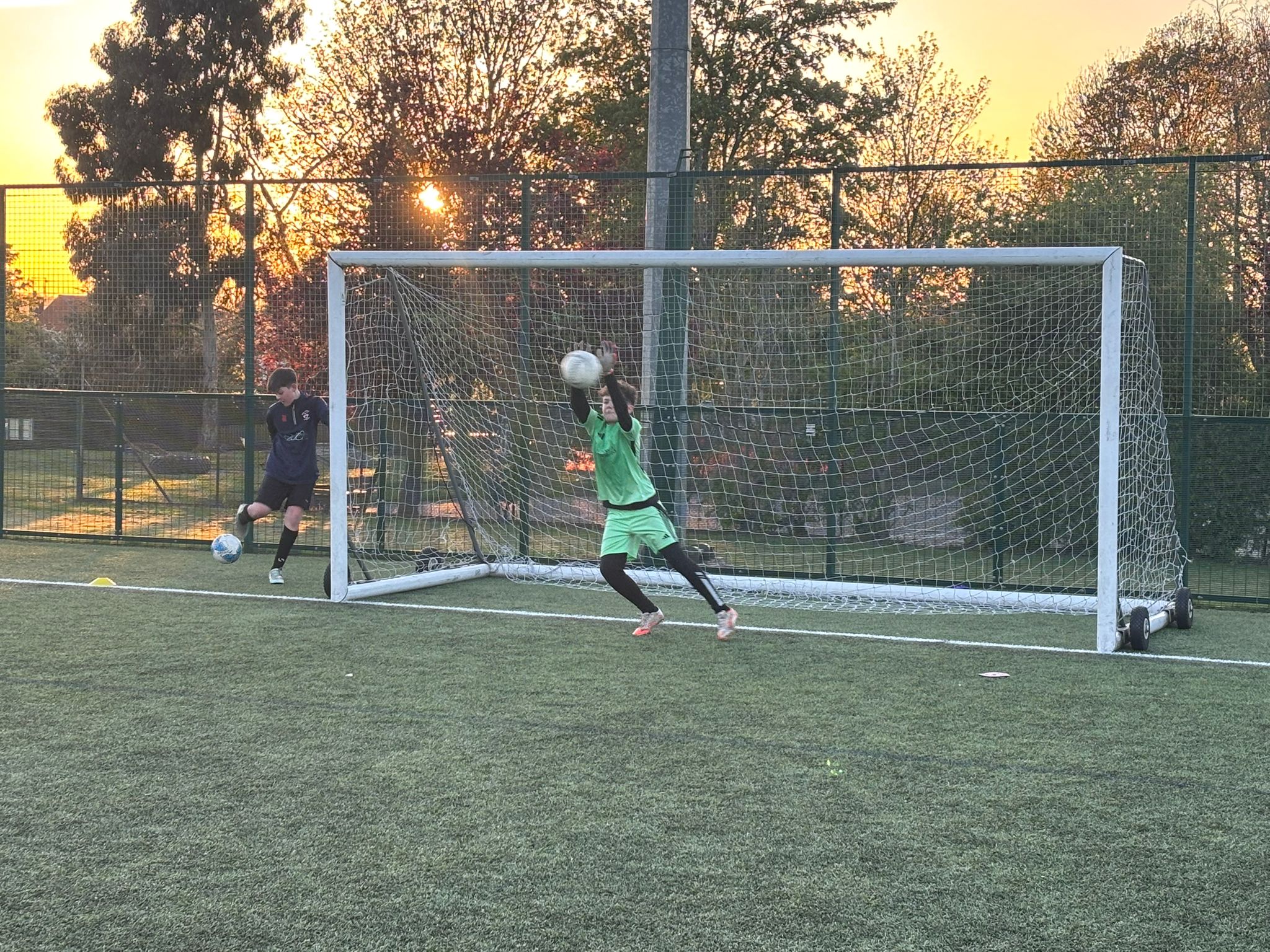Goalkeeper training session at sunset